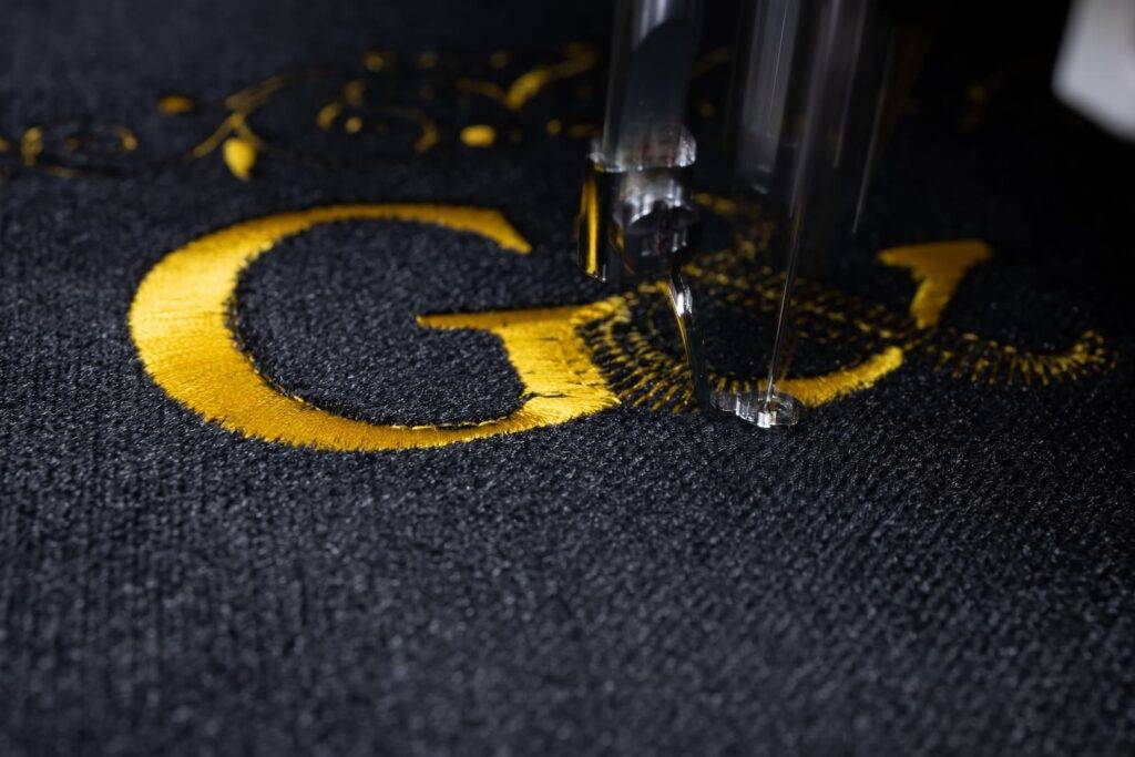 Embroidering workwear. Gold lettering on clothing